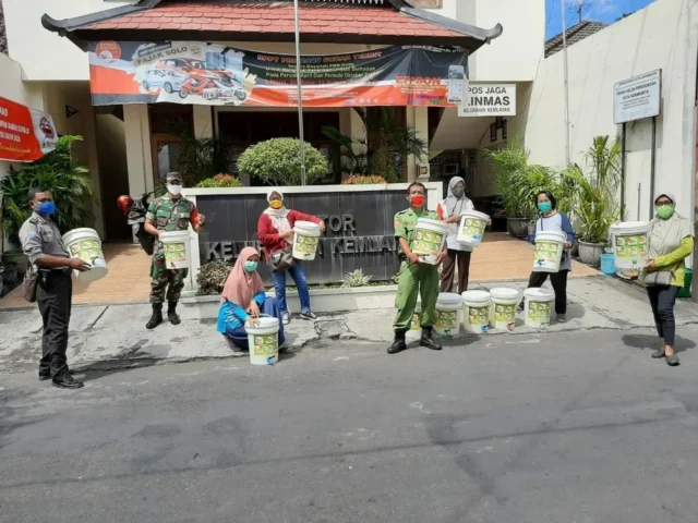 Babinsa Bersama Linmas Bagi-bagi Masker dan Tempat Cuci Tangan