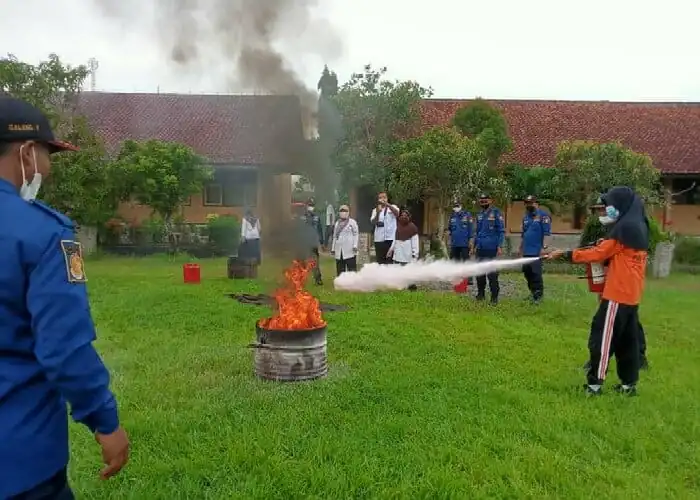 Salah satu siswa saat mengikuti simulasi cara memandamkan api, Rabu (22/12/21) foto: pelita.co