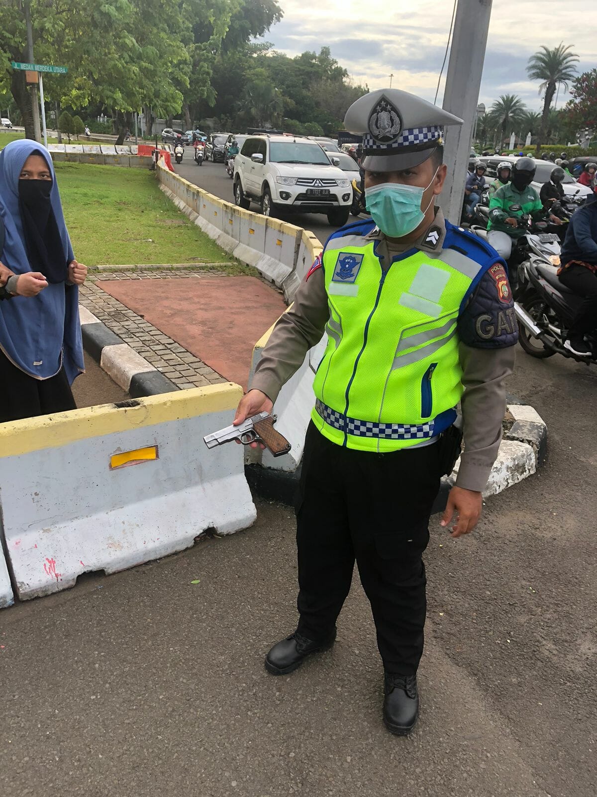 Petugas polisi saat memperlihatkan senjata api jenis FN yang dibawan wanita bercandar.